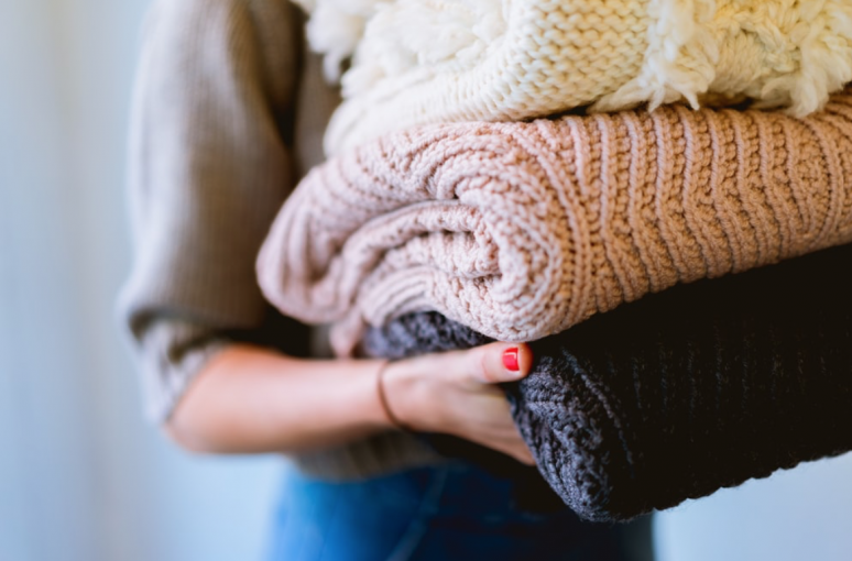 A woman carrying a pile of blankets
