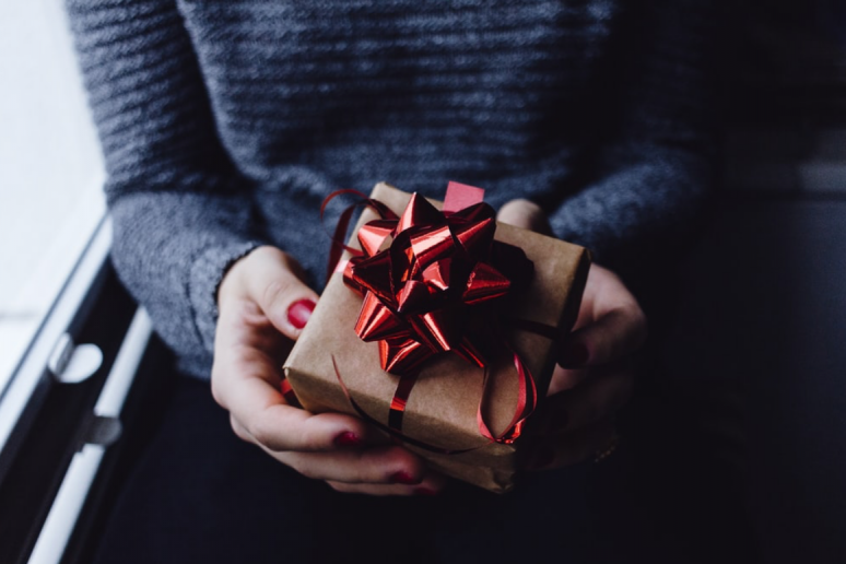 A woman holding a wrapped present
